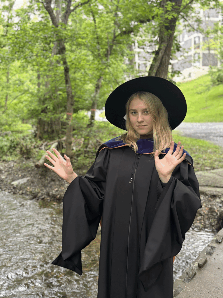 A photo of Emma Batty dressing a graduation gown. 